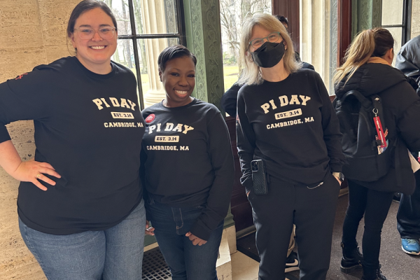 During MIT Pi Day festivities, President Kornbluth poses for a photo opportunity with two smiling students.