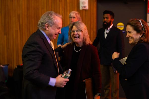 President Kornbluth (center) stands laughing with colleagues at MIT Generative AI Week: Shaping the Future Symposium.