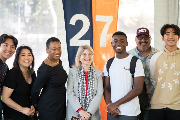 Chancellor Melissa Nobles (left) and President Kornbluth (right) pose and smile in the middle of students at Convocation.